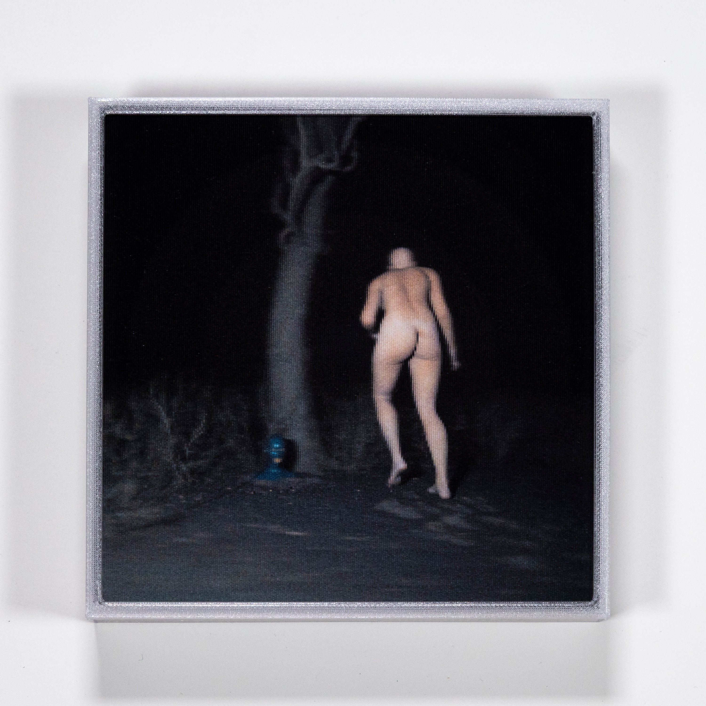 Naked person walking on a dark path with a tree in the background