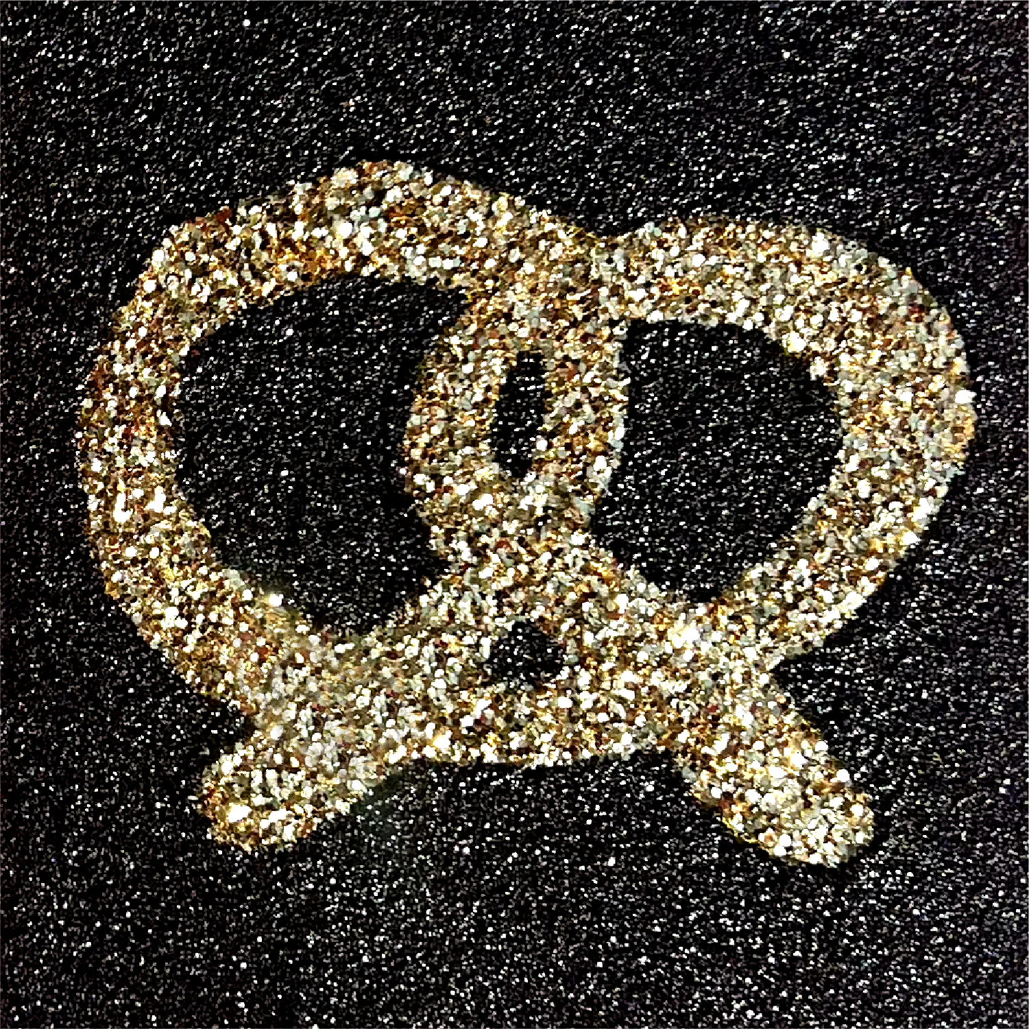 Gold glittery question mark symbol on a black background