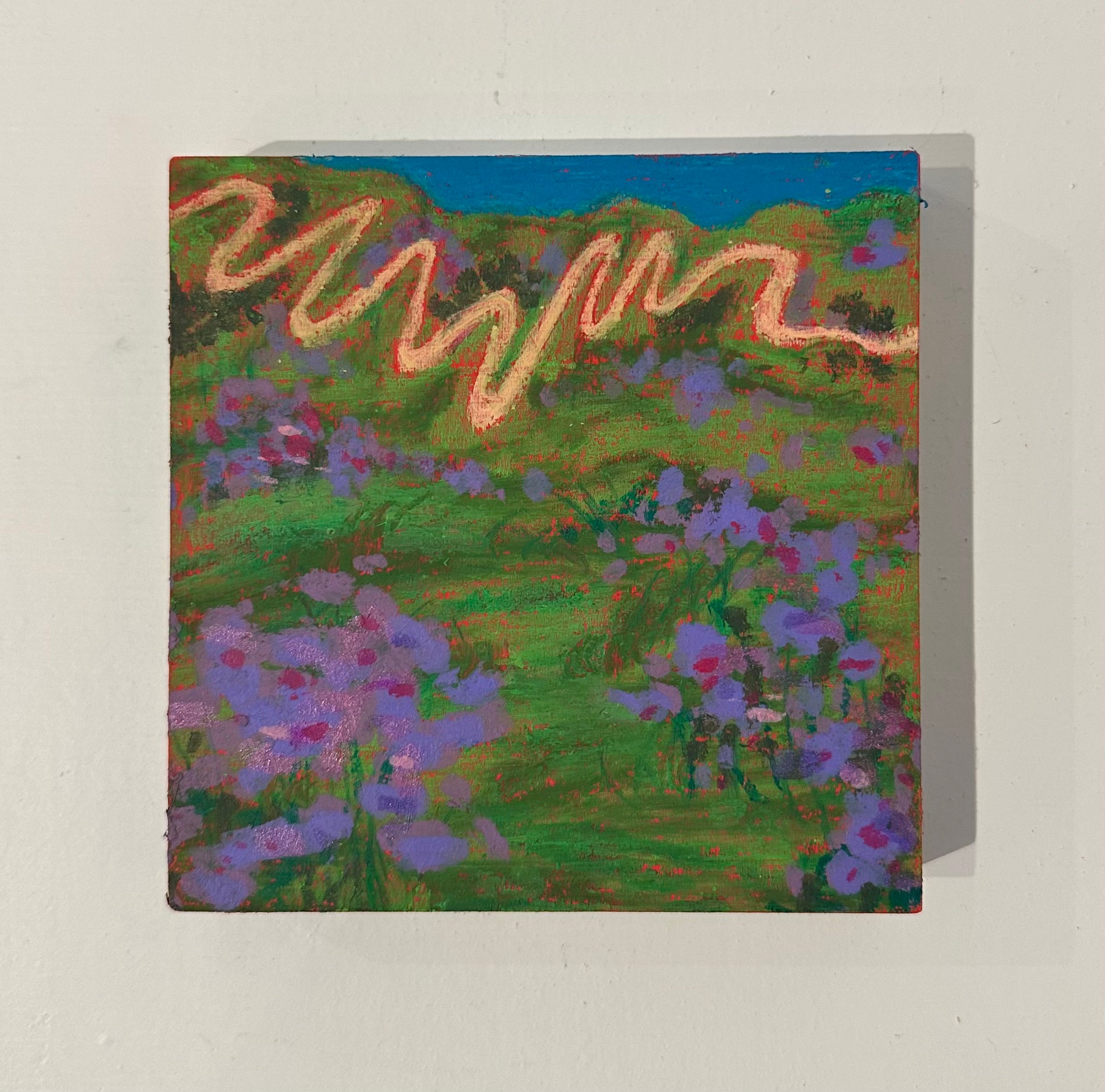 Greeting card with a colorful landscape design featuring purple flowers and green hills.