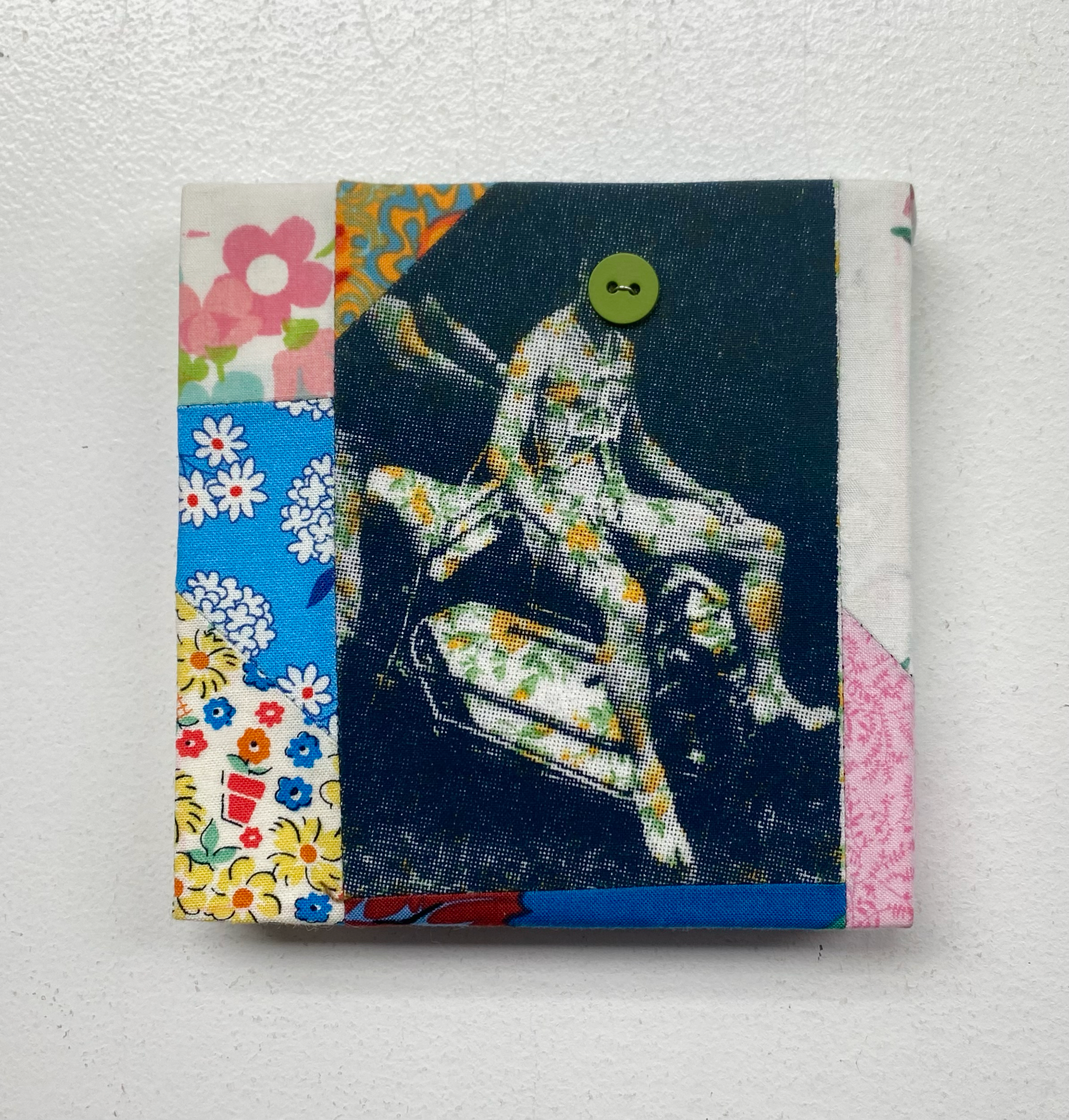 Fabric patchwork with floral patterns and a central design of a person on a horse.