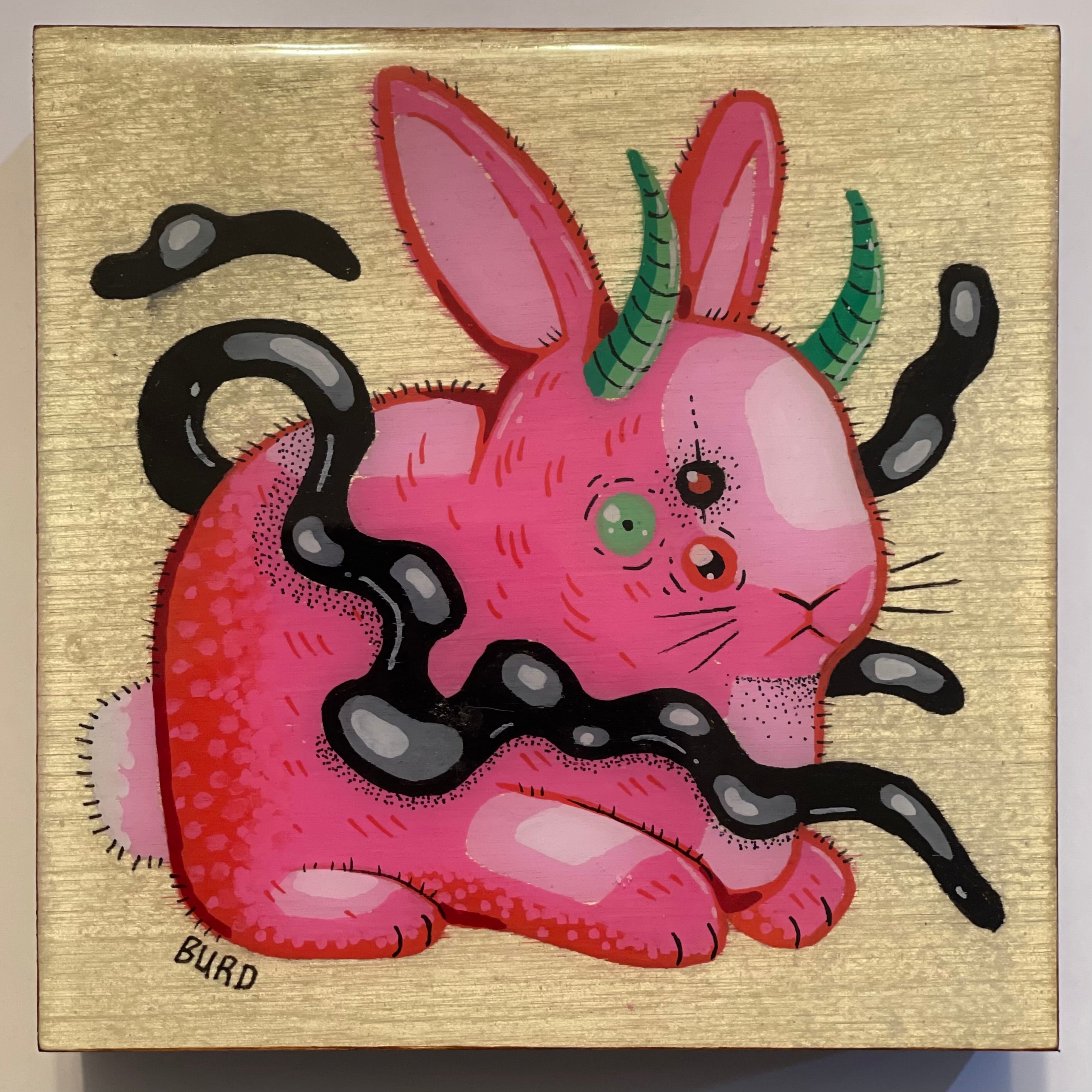 Pink creature with rabbit-like features and black tentacles on a gold background