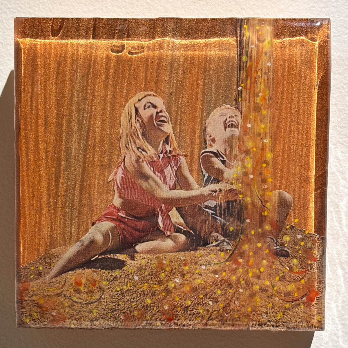 Two people laughing together on a textured surface with warm tones