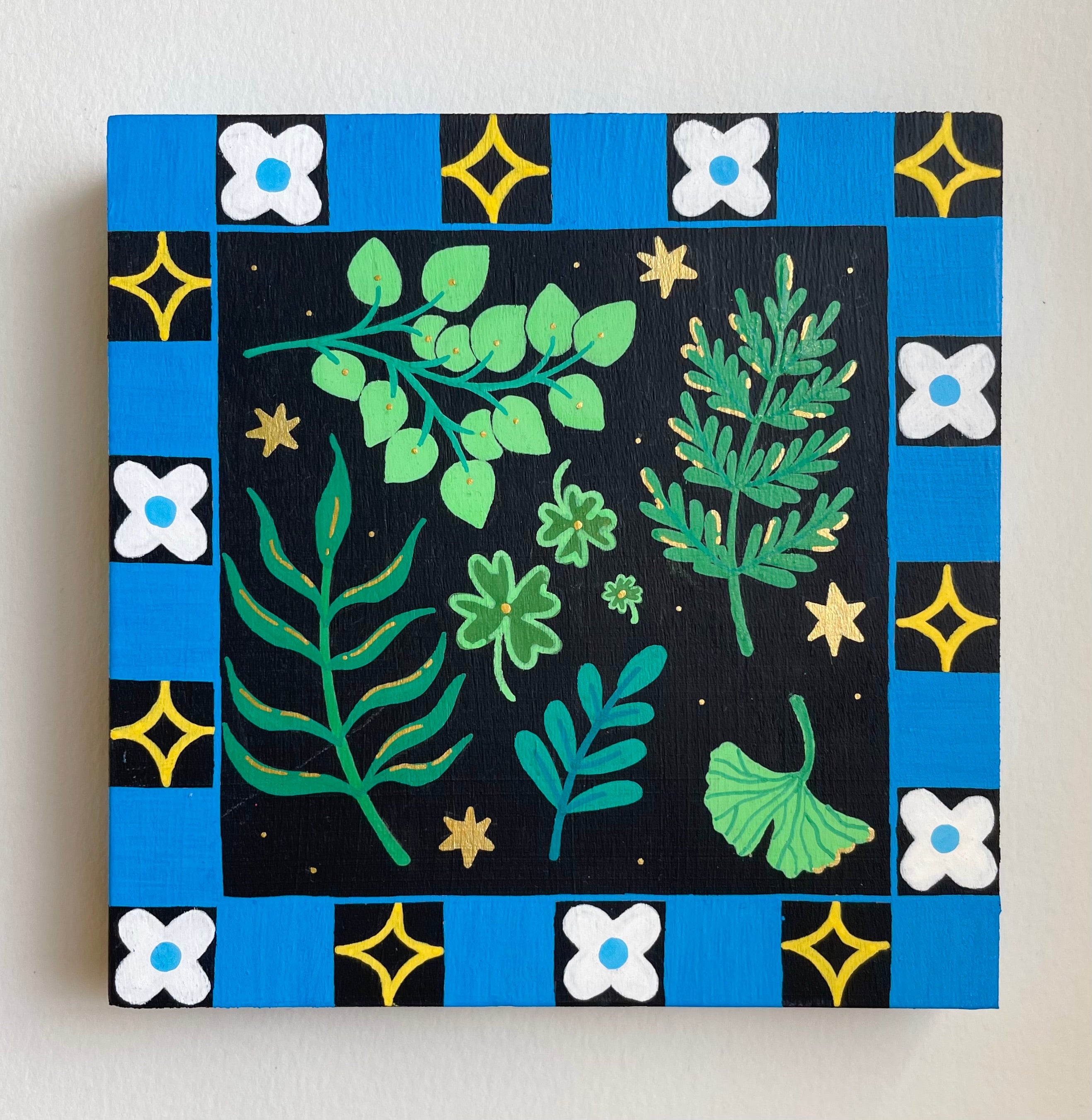 Canvas print with green leafy patterns and blue border on a white background