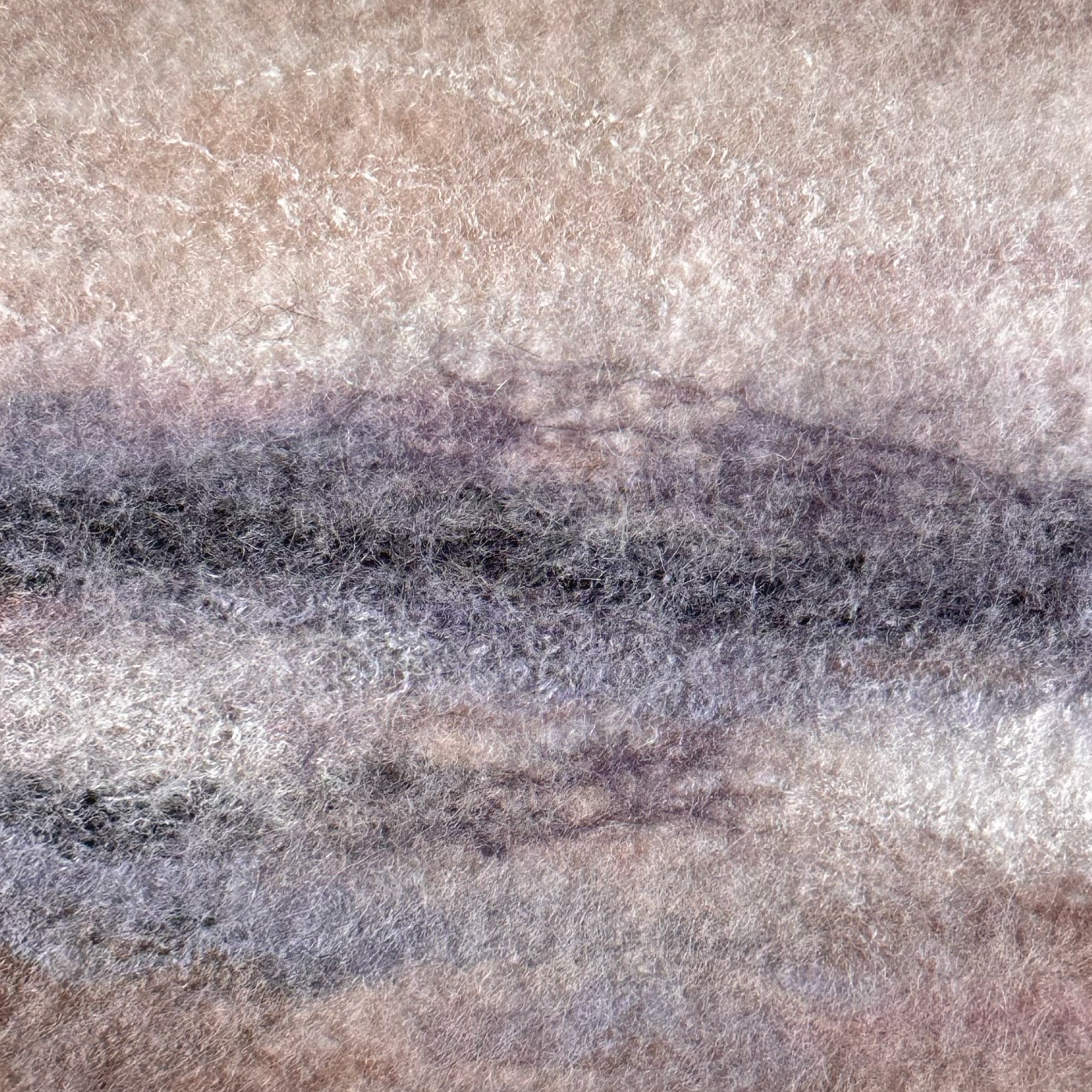 Close-up of a textured stone surface with gray and brown tones