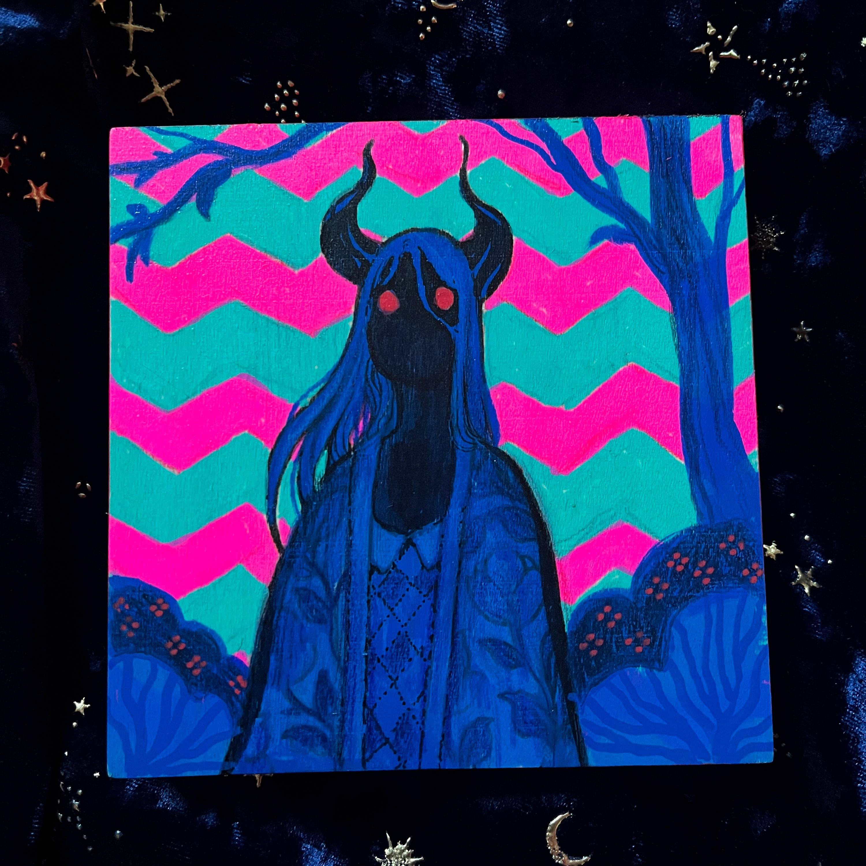 Blue figure with horns against a pink and blue zigzag pattern