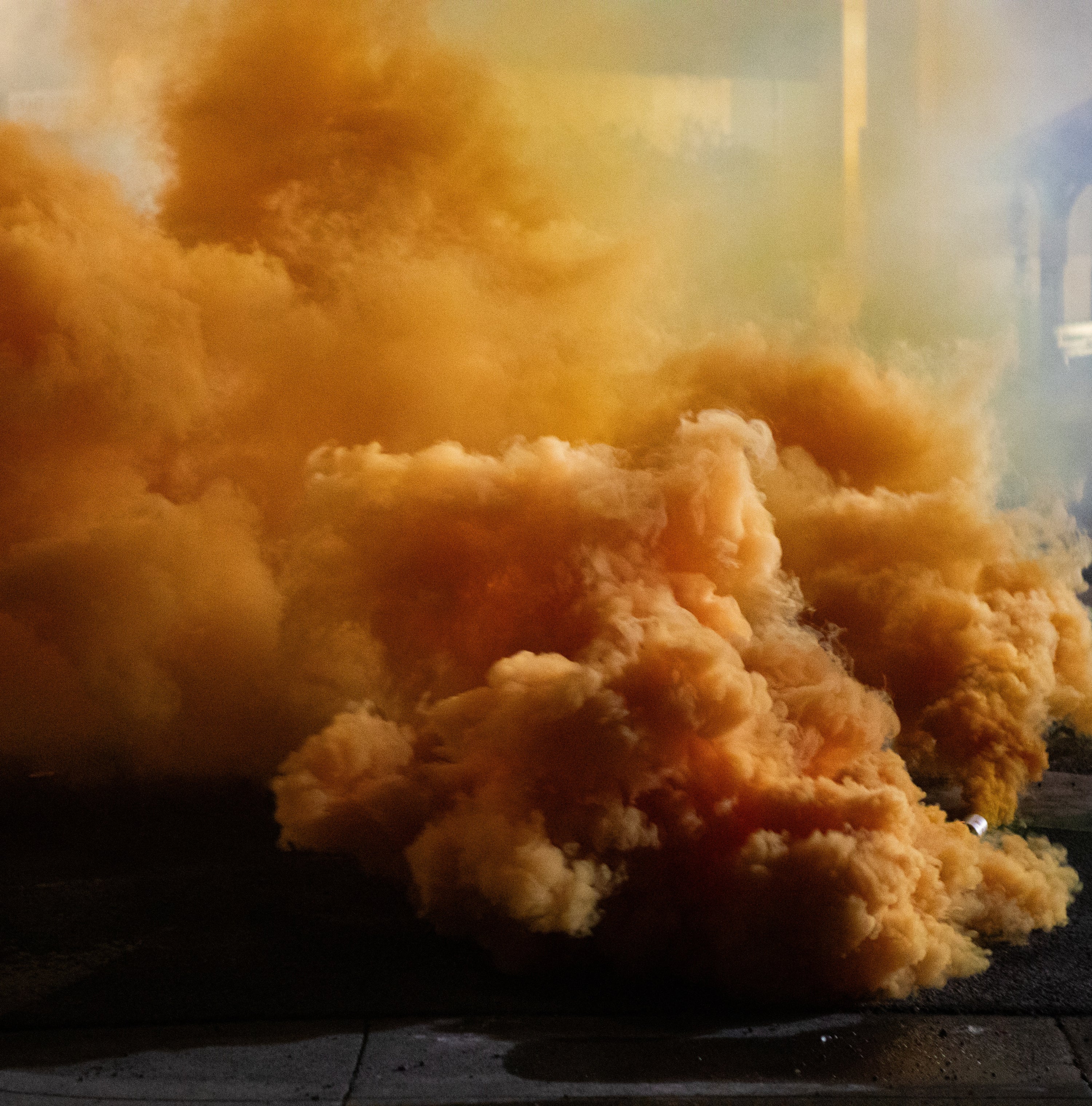 Amber-colored smoke or fibers on a dark surface