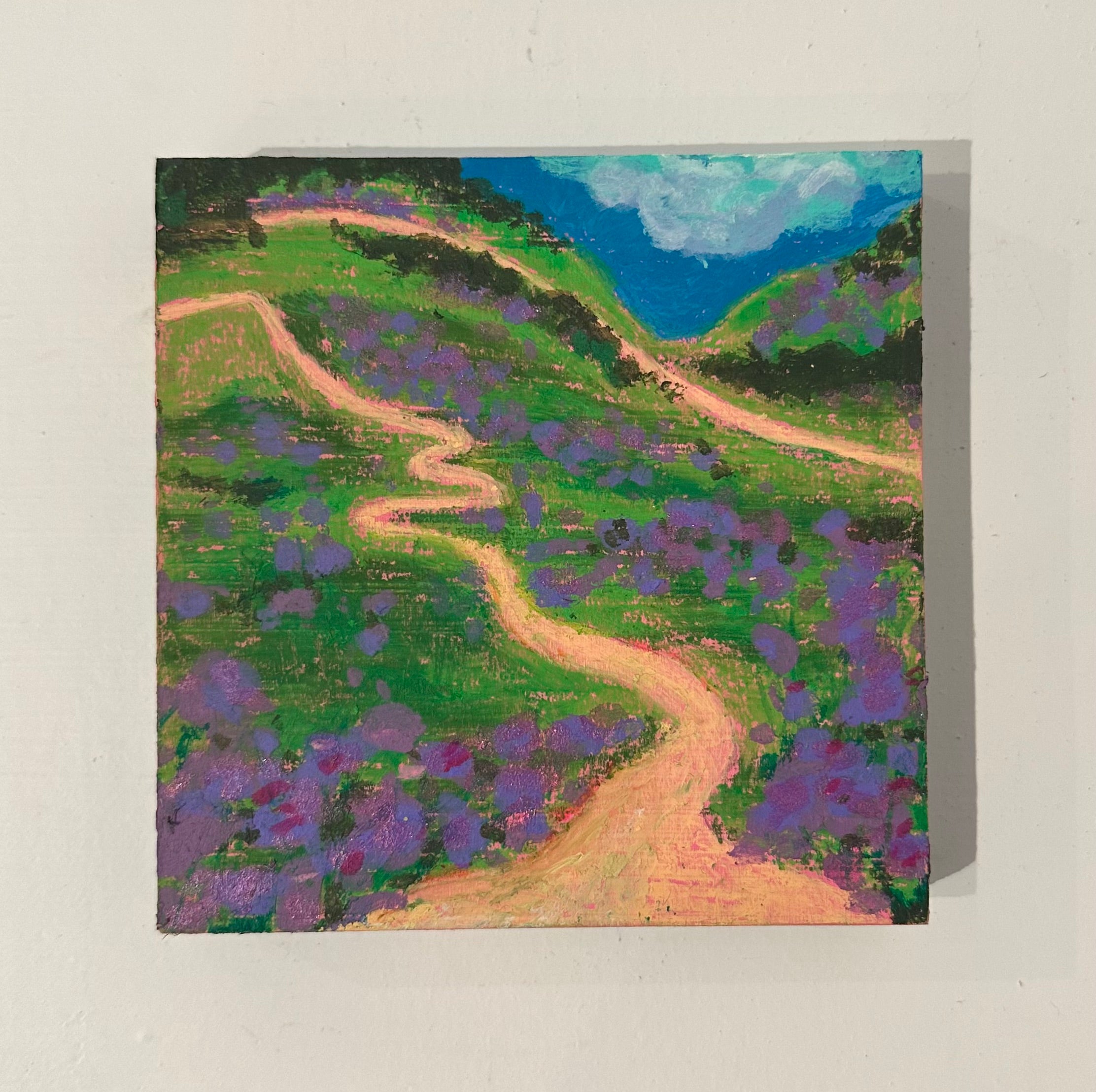 Painting of a winding path through a landscape with purple flowers and green hills.