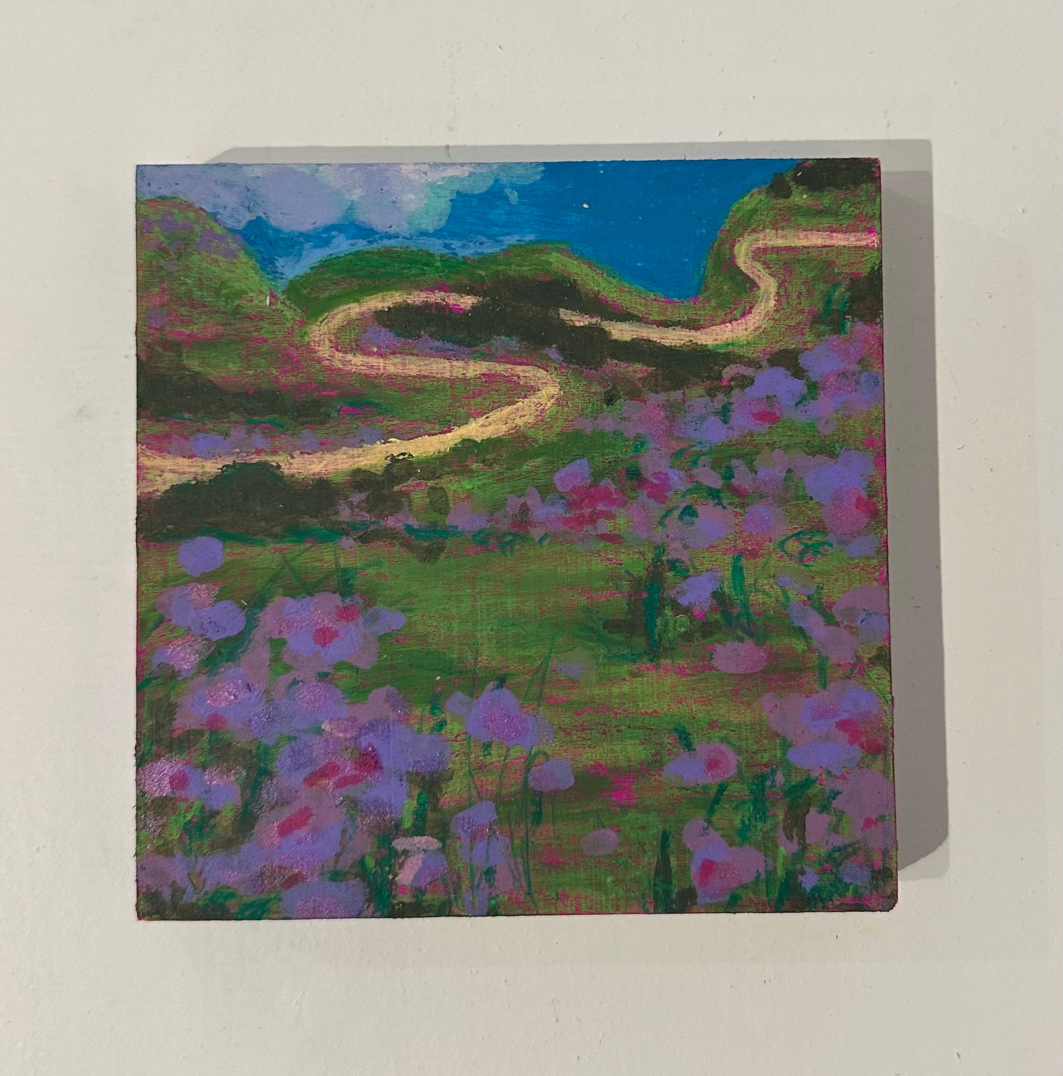 Painting of a winding road through a landscape with flowers
