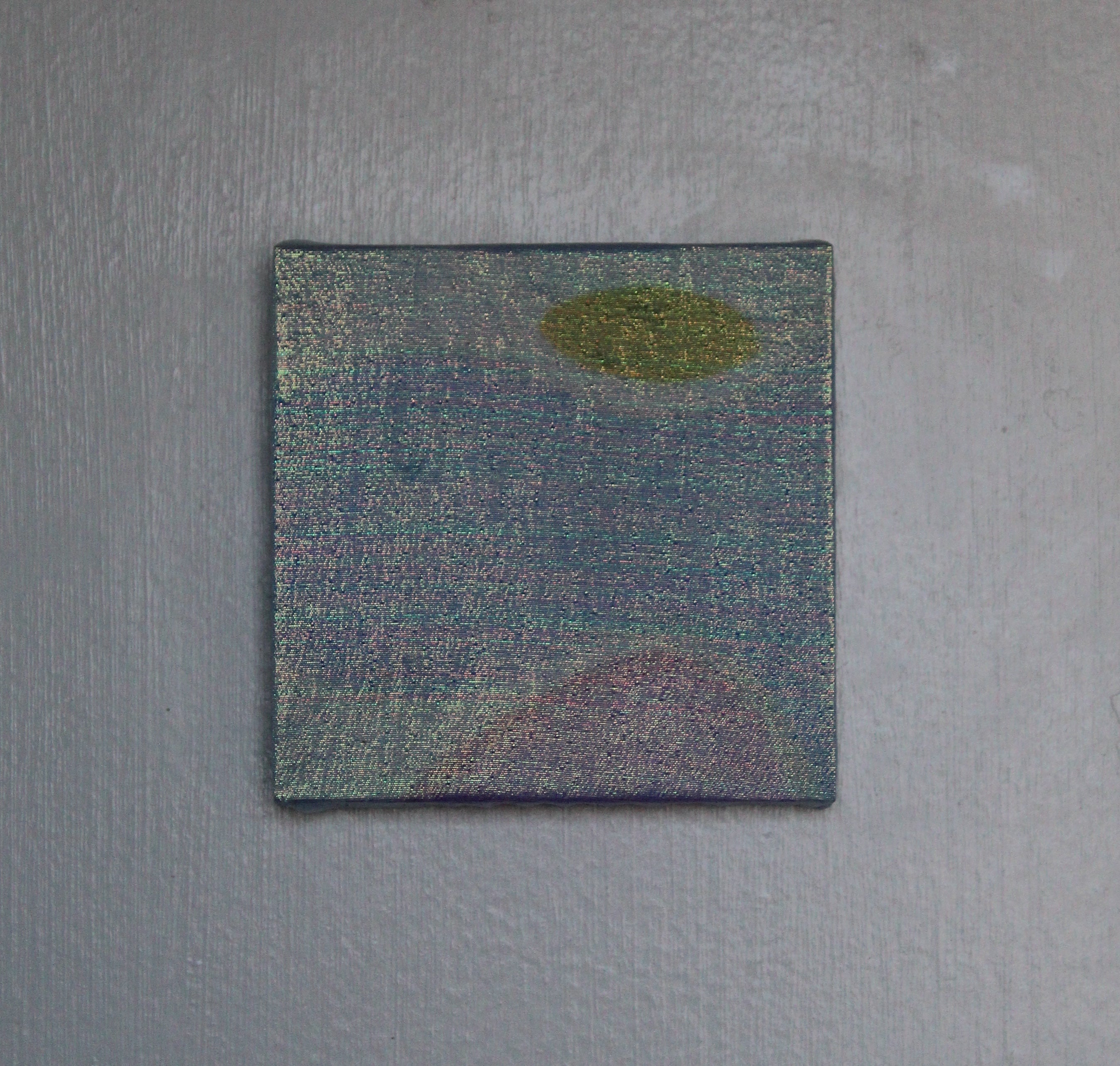 Square patch with a circular design on a textured gray background