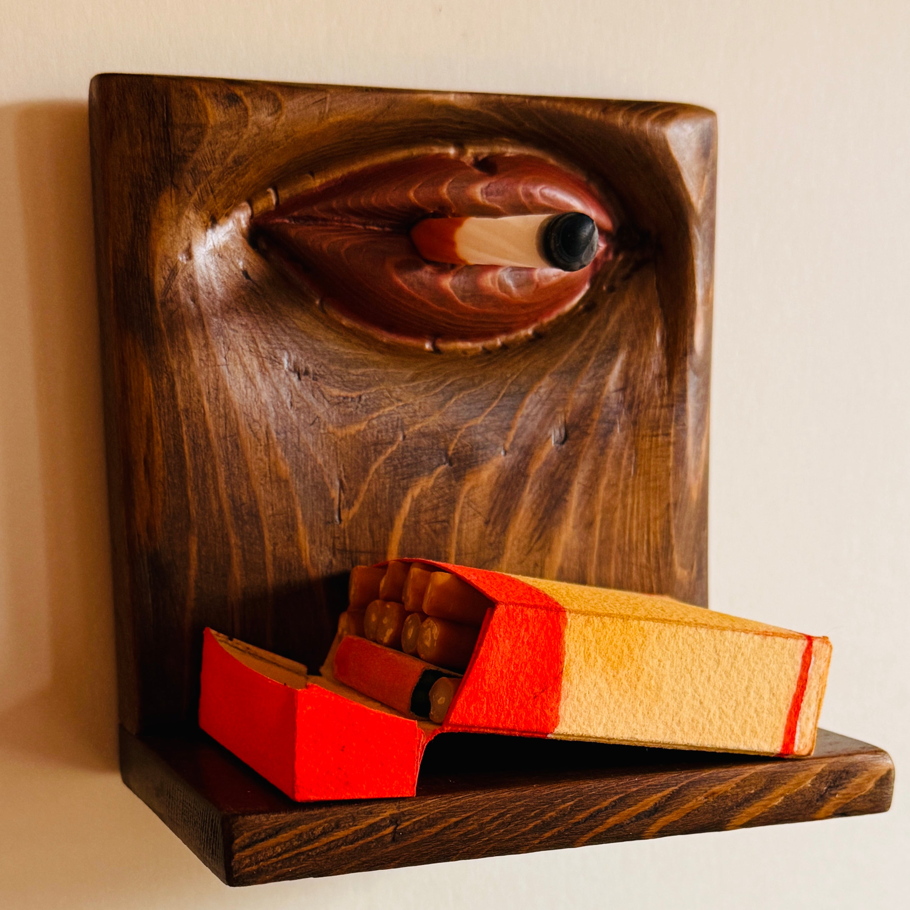 Wooden matchbox holder with matches on a beige background