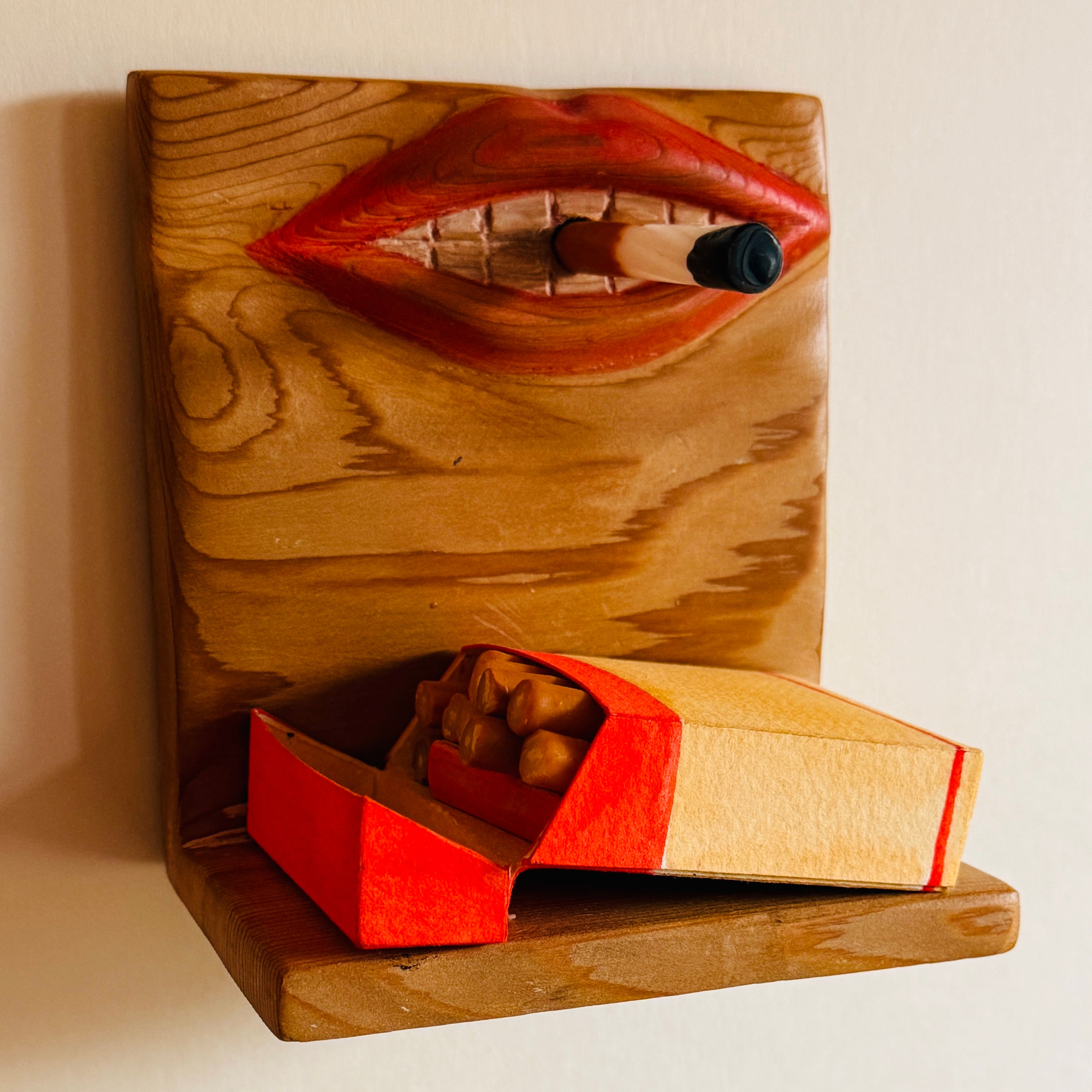 Wooden sculpture of lips with a box of chocolates on a wooden base