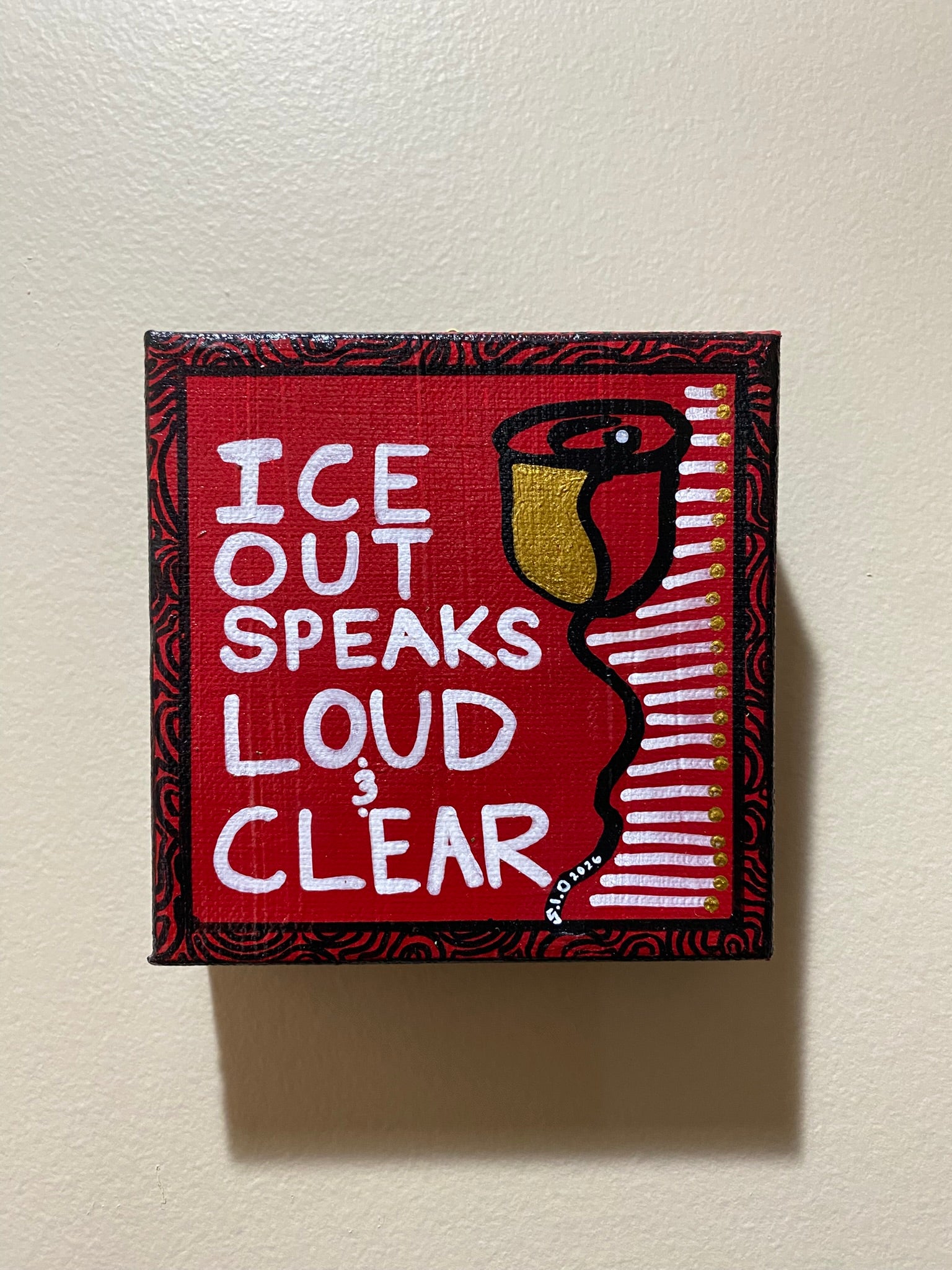 Decorative sign with text 'ICE OUT SPEAKS LOUD & CLEAR' on a red background.