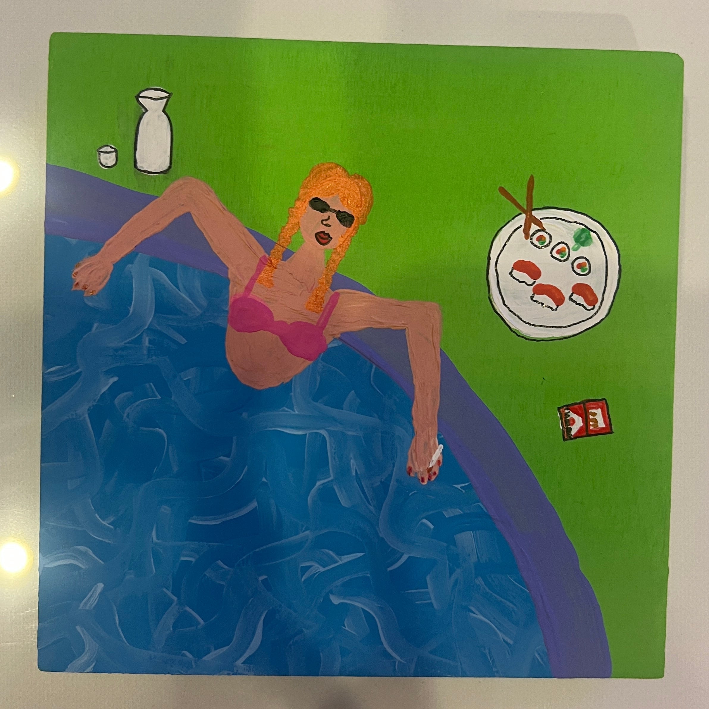 Product packaging with a green background and blue water design, featuring an illustration of a person in a swimsuit.